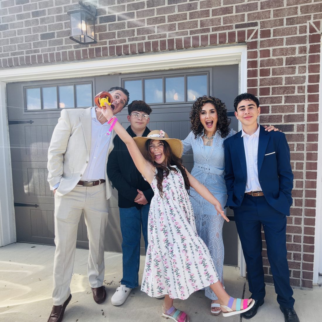 Mike, Vania and their three kids, now older, in front of their home