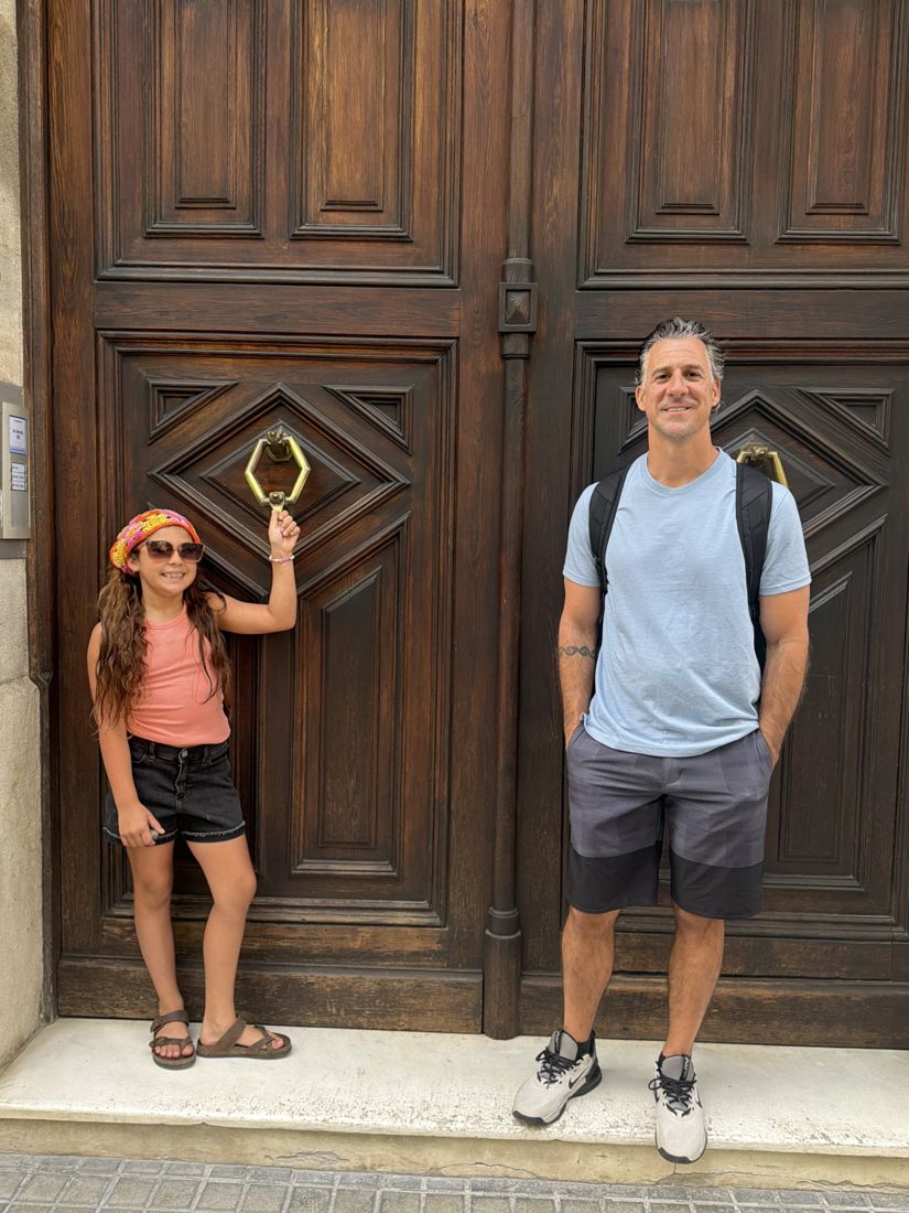 Mike and their daughter by a big carved door